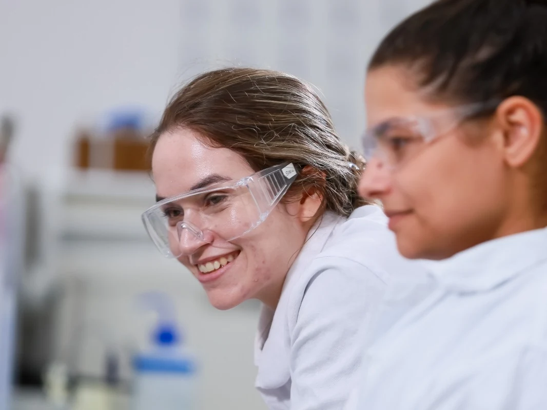 Duas funcionárias da Inpasa de jaleco e óculos de proteção trabalhando no laboratório